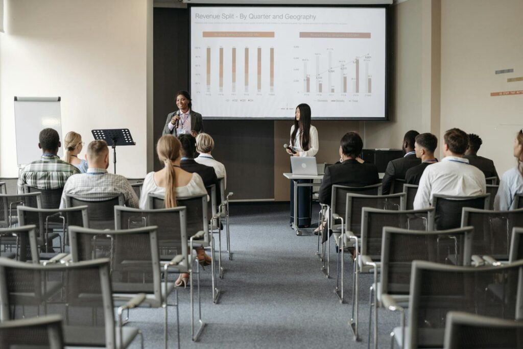 Professional business seminar with audience listening to presenters sharing data insights.